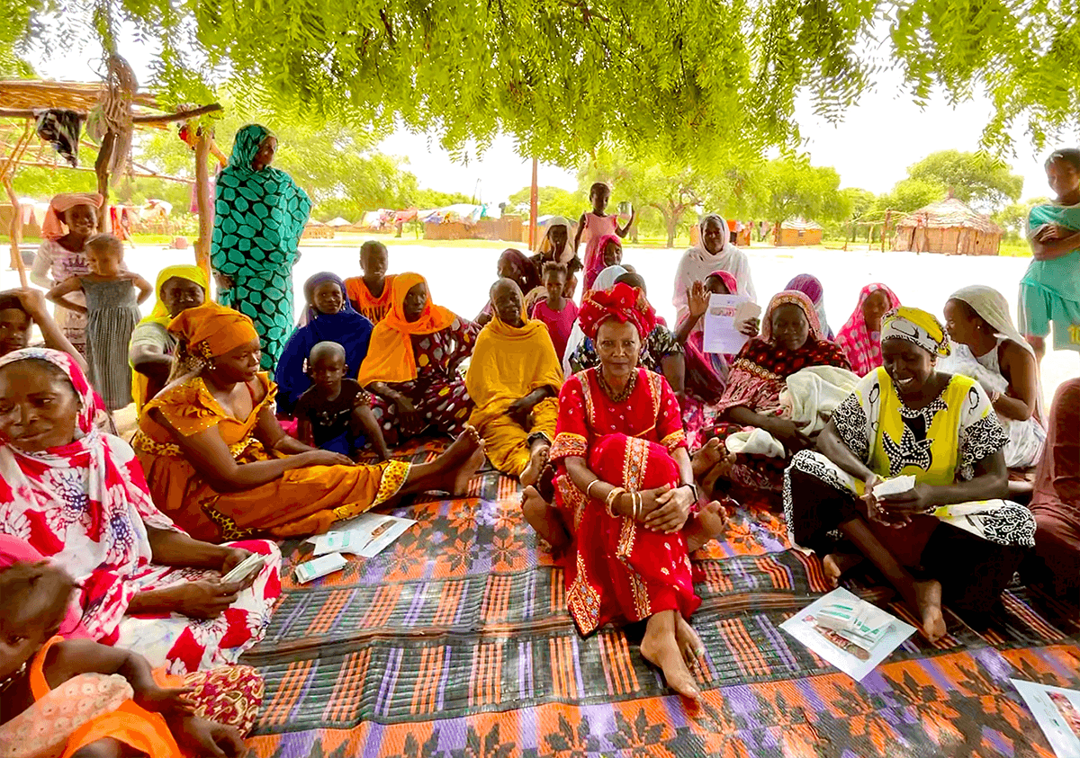 Professor Ozzie Abaye with local villagers under the shade of a neem tree.